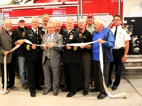BRUCE BELL/THE INTELLIGENCER
Prince Edward County Mayor Robert Quaiff gets a hand from Fire Chief Scott Manlow (left) and Deputy Fire Chief Robert Rutter (right) cutting a piece of fire hose at the grand opening of the new Fire and Rescue Station 1 and Hastings Quinte Paramedic Services facility Thursday night. They are joined (from left) by councillors Gord Fox, Bill Roberts, Brad Nieman, Barry Turpin, Jim Dunlop, David Harrison, Roy Pennell and Division 1 commander Rob Manlow.