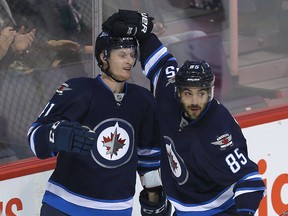 Winnipeg Jets left winger Kyle Connor (left) celebrates his second period goal against the Minnesota Wild with centre Mathieu Perreault Thursday night. (Brian Donogh/Winnipeg Sun)