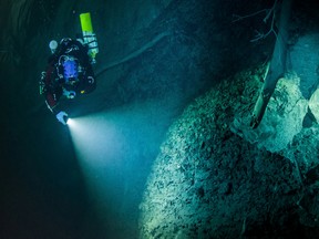 In this underwater photo taken Aug. 15, 2015 in the flooded Hranicka Propast, or Hranice Abyss, in the Czech Republic is seen Polish explorer Krzysztof Starnawski exploring the limestone abyss and preparing for deeper exploration with the use of a remotely-operated underwater robot, or ROV. On Sept. 27, 2016, the robot went to the record depth of 404 meters (1,325 feet) revealing the abyss to be the world's deepest flooded cave, during the 'Hranicka Propast - step beyond 400m' expedition led by Starnawski and partly funded by the National Geographic. (Krzysztof Starnawski of EXPEDITION via AP)