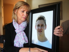 Bev Geddes hugs a photo of her son Colin Edmond. Colin died from suicide. (Brian Donogh/Winnipeg Sun)