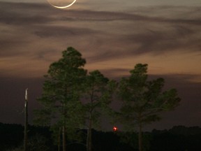 In this Jan. 9, 2008, file photo, one day past New, an early Waxing Crescent Moon is seen just after sunset from Tyler, Texas. A rare "black moon" rises over the Western Hemisphere on Friday, Sept. 30, 2016. A black moon is the second new moon in a calendar month. (AP Photo/Dr. Scott M. Lieberman, File)