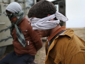 Suspected ISIS fighters are detained by Kurdish Peshmerga forces after they fled their frontline village to a Kurdish-controlled area on November 16, 2015 to Sinjar, Iraq. (Photo by John Moore/Getty Images)