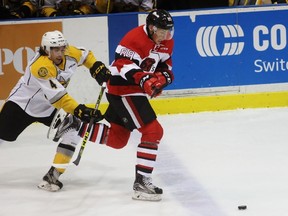 Sasha Chmelevski of the Ottawa 67's beats Sarnia Sting defenceman Jeff King to a loose puck during the Ontario Hockey League game at Progressive Auto Sales Arena on Friday, Sept. 30, 2016 in Sarnia, Ont. Chmelevski, a former Sting first-round draft pick, played against his old team for the first time since being traded lasts season and scored a power-play goal. (Terry Bridge/Sarnia Observer)