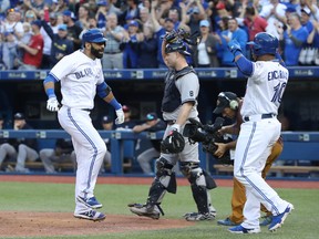 Jose Bautista of the Toronto Blue Jays celebrates his three-run home run with teammate Edwin Encarnacion during a game against the New York Yankees on Sept. 24, 2016 at Rogers Centre in Toronto. (Tom Szczerbowski/Getty Images)