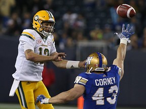 Edmonton Eskimos QB Mike Reilly dumps a pass off over Winnipeg Blue Bombers DE Trent Corney. (KEVIN KING/Winnipeg Sun)