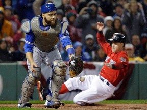 Toronto Blue Jays catcher Russell Martin can't handle the throw as Boston Red Sox's Brock Holt slides into home to score during the first inning at Fenway Park on Sept. 30, 2016. (AP Photo/Elise Amendola)