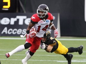 Calgary Stampeders running back Roy Finch gaining yards while defending by Hamilton Tiger-Cats defensive back Mike Daly during the first-half of CFL football action in Hamilton, Ont., on Saturday, October 1, 2016. (THE CANADIAN PRESS/Peter Power)