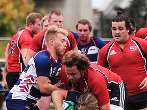 A Loyalist Lancers ballcarrier goes to ground during OCAA men's rugby action Saturday vs. St. Lawrence College in Kingston. At right is Trenton native Ty Shemko of SLC. (SLC Athletics photo)