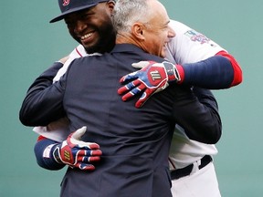 Boston Red Sox DH David Ortiz and MLB commissioner Rob Manfred share a hug during a ceremony to honour Ortiz before the Red Sox played the Blue Jays on Oct. 2, 2016. (MICHAEL DWYER/AP)