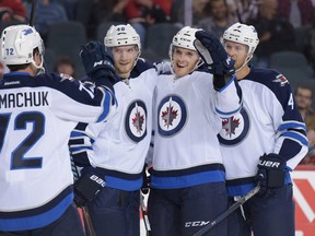 Ben Chiarot celebrates with fellow Winnipeg Jets after scoring the second goal in a pre-season game against the Calgary Flames at the Scotiabank Saddledome in Calgary, Alta., on Sunday, Oct. 2, 2016. Elizabeth Cameron/Postmedia