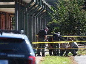 Members of law enforcement investigate an area at Townville Elementary School on Wednesday, Sept. 28, 2016, in Townville, S.C. A teenager opened fire at the South Carolina elementary school Wednesday, wounding two students and a teacher before the suspect was taken into custody, authorities said.  (AP Photo/Rainier Ehrhardt)
