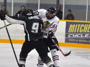 Mackinnon Hawkins (23) of the Mitchell Hawks knocks Michael Stefanelli (9) of the Mount Forest Patriots off  the puck during Provincial Junior Hockey League (PJHL) action in Mitchell last Sunday, Oct. 2. The Hawks won, 6-2. ANDY BADER MITCHELL ADVOCATE