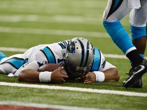 Panthers quarterback Cam Newton lies on the turf after a hit during a two-point conversion against the Falcons during second half NFL action in Atlanta on Sunday, Oct. 2, 2016. (Rainier Ehrhardt/AP Photo)