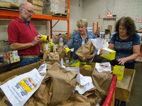 Tom Grayson, Lynda Aristone and Linda Binckly sort food as part of the Thanksgiving food drive at the London Food Bank in London. Food can be dropped off at all major grocery stores and London?s 14 fire halls up until Oct. 10. (MIKE HENSEN, The London Free Press)