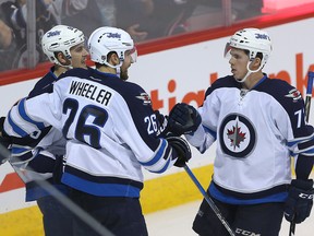 Winnipeg Jets center Mark Scheifele (l) celebrates his second period goal against the Ottawa Senators with wingers Blake Wheeler (c) and Scott Kosmachuk during NHL hockey in Winnipeg, Man. Monday October 03, 2016. Brian Donogh/Winnipeg Sun/Postmedia Network