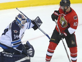 Jets goalie Michael Hutchinson (left) deflects a shot over Senators left winger Tom Pyatt during NHL pre-season action in Winnipeg on Monday, Oct. 3, 2016. (Brian Donogh/Postmedia Network)