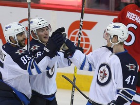 Winnipeg Jets left winger Kyle Connor (r) celebrates his third period goal against the Ottawa Senators with Mathieu Perreault (l) and Marko Dano during NHL hockey in Winnipeg, Man. Monday October 03, 2016. Brian Donogh/Winnipeg Sun/Postmedia Network