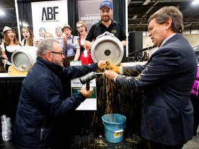 Edmonton City Councillor Tony Caterina and Minister of Agriculture and Forestry Oneil Carlier tap a keg to open the Edmonton Oktoberfest at the Edmonton Expo Centre, in Edmonton on Friday Sept. 30, 2016. Photo by David Bloom