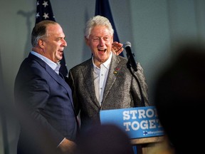 Former President Bill Clinton smiles as he hugs U.S. Rep. Dan Kildee, D-Flint Township, after introducing him to speak, Monday, Oct. 3, 2016 at Northbank Center in downtown Flint, Mich. (Jake May/The Flint Journal via AP)