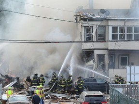Two multifamily houses were destroyed in an explosion Tuesday morning, Oct. 4, 2016, shortly after firefighters arrived to investigate a possible gas leak and evacuated residents in Paterson, N.J. A third home was so badly damaged it would have to be razed, officials said. Five Paterson firefighters were taken to the hospital with minor injuries, according to Paterson Fire Chief Michael Postorino. (Tariq Zehawi/Northjersey.com/The Record via AP)