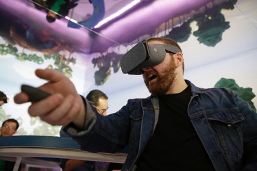 Dan Howley tries out the Google Daydream View virtual-reality headset and controller following a product event, Tuesday, Oct. 4, 2016, in San Francisco. (AP Photo/Eric Risberg)