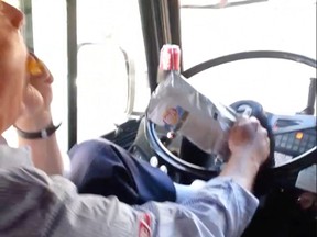 A TTC bus driver eats potato chips while driving with his foot on the dashboard in this still image taken from video.