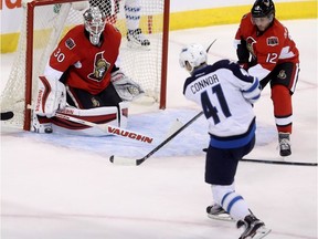 Ottawa Senators goaltender Andrew Hammond (30) stops Winnipeg Jets' Kyle Connor (41) during first period pre-season NHL hockey in Winnipeg, Monday, October 3, 2016. THE CANADIAN PRESS/Trevor Hagan