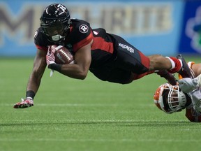 Ottawa Redblacks' Mossis Madu Jr. is stopped by B.C. Lions' Craig Roh during the second half of a CFL football game in Vancouver on Oct. 1, 2016. (THE CANADIAN PRESS/Darryl Dyck)
