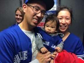 Blue Jays fans of all ages, including five-month-old  Declan,  and his parents — Tan and Winnie — turned up for Tuesday night's wild card game at the Rogers Centre. (JOE WARMINGTON PHOTO)