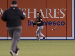 Baltimore Orioles' Hyun Soo Kim gets under a fly ball as a beer can sails past him during seventh inning American League wild-card game action against the Toronto Blue Jays in Toronto, Tuesday, Oct. 4, 2016. THE CANADIAN PRESS/Mark Blinch