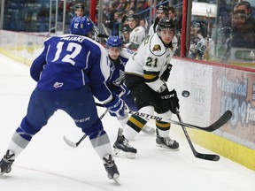 C.J. Yakimowicz, right, of the London Knights, flips the puck past Brady Pataki, of the Sudbury Wolves, during OHL action at the Sudbury Community Arena in February 2015. JOHN LAPPA/THE SUDBURY STAR/QMI AGENCY