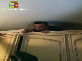 In this image taken from a video fugitive ‘Ndrangheta mob boss Antonio Pelle comes out of the closet to surrender himself after five years on the lam, in Reggio Calabria, Italy, Wednesday, Oct. 5, 2016. (Italian Police via AP)