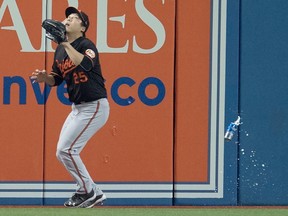 A beer can lands near Baltimore Orioles leftfielder Hyun Soo Kim as he gets set to catch a fly ball during the seventh inning of the wild-card game against the Toronto Blue Jays in Toronto on Oct.4, 2016. (THE CANADIAN PRESS/Frank Gunn)