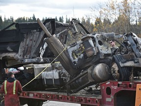 Workers strap down a semi dump truck on a flatbed trailer after it burst into flames after colliding with a utility truck about 4 am on the westbound portion of the Rainbow Valley Bridge on Whitemud Dr. in Edmonton Wednesday, October 5, 2016. The Whitemud west was closed till mid afternoon and so far no serious injures reported. Ed Kaiser/Postmedia