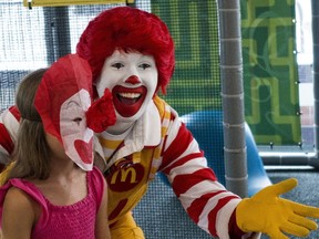 Ronald McDonald entertains a young girl during his appearance at a McDonalds's August 10, 2015, in Centreville, Virginia. (PAUL J. RICHARDS/AFP/Getty Images)