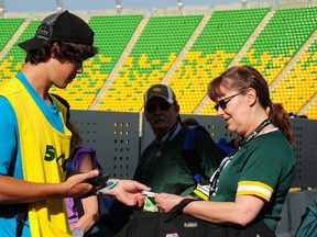 A volunteer sells 50/50 tickets at a July 2014 game where a $71,732 carryover that went unclaimed a week earlier contributed to a take-home prize of $348,534 – a North American record. (File)