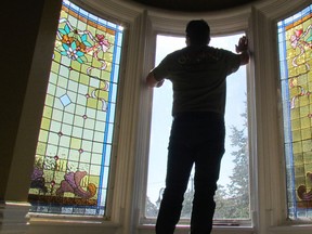 Adam Frazee of London's Sunrise Stained Glass prepares to install a restored window in the turret of the Lawrence House on Wednesday October 5, 2016 in Sarnia, Ont. (Paul Morden/Sarnia Observer/Postmedia Network)