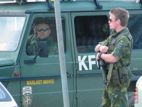 Swedish soldiers, part of the KFOR peacekeeping mission in Kosovo, maintain watch over the Mitrovica bridge in Kosovo. (Postmedia Network)