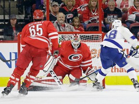 Tampa Bay Lightning's Ondrej Palat (18), of the Czech Republic, scores during overtime against Carolina Hurricanes goalie Michael Leighton as Hurricanes' Ron Hainsey (65) watches in an exhibition NHL hockey game in Raleigh, N.C., Friday, Sept. 30, 2016. Tampa Bay won 2-1. (AP Photo/Gerry Broome)