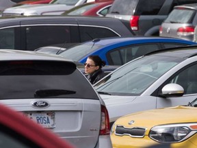 A woman in a sea of vehicles in the parking lot located behind the Civic Hospital. There are early signs that parking will be the next battle on the road to a new $2 billion super hospital in Ottawa. WAYNE CUDDINGTON / POSTMEDIA