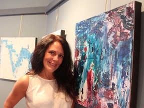 Kirsten Anderson poses with "Comb," for which she painted with a comb, using dark green, dark blue and magenta. The Sarnia artist has 13 abstract paintings at the Lawrence House this month in an exhibit called Collective Suggestion: A Social Experiment. It opens Friday, 6-9 p.m. (Tyler Kula/Sarnia Observer)