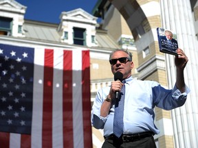 Democratic vice presidential candidate Tim Kaine uses a Donald Trump book as a talking point during a rally on the campus of Carnegie Mellon University, Thursday, Oct. 6, 2016 in Pittsburgh. (Rebecca Droke/Pittsburgh Post-Gazette via AP)