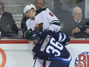 Winnipeg Jets defenceman Josh Morrissey (l) checks Minnesota Wild defenceman Marco Scandella during NHL hockey in Winnipeg, Man. Thursday September 29, 2016.