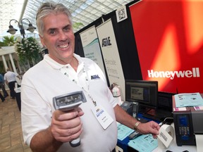 Ron Ford of AGiiLE Inc., a manufacturer that specializes in bar coding products, shows off a scanner at their booth at the Manufacturing Matters trade show and conference at the Best Western Lamplighter Inn in London, Ont. on Thursday October 6, 2016. (CRAIG GLOVER, The London Free Press)