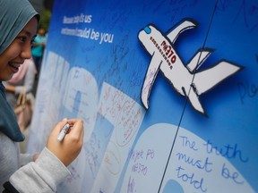 A Malaysian woman writes well wishes on a wall of hope during a remembrance event for the ill fated Malaysia Airlines Flight 370 in Kuala Lumpur, Malaysia, Sunday, March 6, 2016. At the commemorative event Sunday to mark the second anniversary of the jet’s March 8, 2014, disappearance, the families of Flight 370 passengers released white balloons tagged with the names of everyone aboard the plane and the words: “MH370: Always remembered in our hearts.” (AP Photo/Joshua Paul)