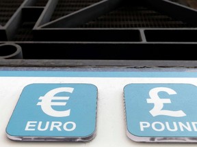 In this Oct. 4, 2016 file photo, Pound and Euro signs are seen above a cashpoint in London. The beleaguered British pound plummeted briefly to a fresh 31-year low Friday, Oct. 7, 2016, amid intensifying concerns about Britain's exit from the European Union. (AP Photo/Kirsty Wigglesworth, File)