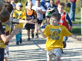 Young fans offer encouragement to Rylan Popma, a Grade 2 student, by offering high-fives in the seven-year-old boys race at the 26th annual Pat Cook Memorial Run hosted by Stratford St. Michael Catholic Secondary School in Stratford last Tuesday, Oct. 4. More than 1,350 runners of all age groups participated from the area in a fantastic fall day, with many local runners doing well. SCOTT WISHART PORTMEDIA NETWORK