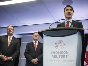 Prime Minister Justin Trudeau addresses an audience of media and stakeholders as President and CEO of Thomson Reuters James C. Smith, left, Toronto Mayor John Tory look on in Toronto on Friday October 7, 2016. Thomson Reuters unveiled plans Friday to create 400 jobs in Canada over the next two years, including at a new technology centre in Toronto. THE CANADIAN PRESS/Christopher Katsarov