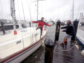 Rick Hushla, right, lends a hand to his wife Susan, after they made some adjustments to their boat at the Cocoa Village Marina as Hurricane Matthew passes through,  Friday, Oct. 7, 2016, in Cocoa, Fla. (AP Photo/John Raoux)