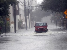 A motorist drives down flooded street in St. Augustine, Fla., as Hurricane Matthew moves up the Florida coast Friday, Oct. 7, 2016. (AP Photo/John Bazemore)